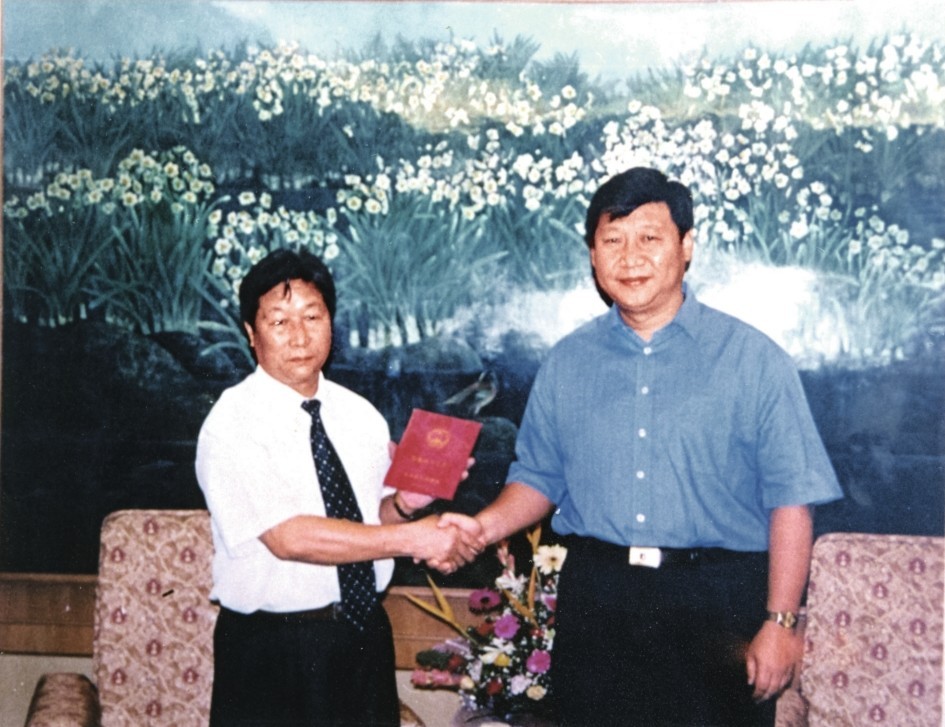 2000年7月，習(xí)近平為福建農(nóng)林大學(xué)教授林占熺頒發(fā)福建省政府“一等功”榮譽(yù)證書。圖源：《習(xí)近平在福建》（下）