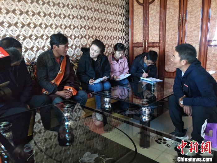 圖為調(diào)查組工作人員正在入戶調(diào)查。　祁增蓓 攝