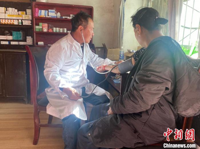 索木滾(左)為村民看病?！∪捞量h委宣傳部供圖
