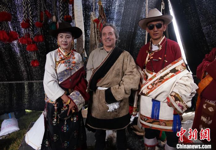 圖為一名外籍?dāng)z影師(中)身穿藏服和藏族民眾合影留念?！●R銘言 攝