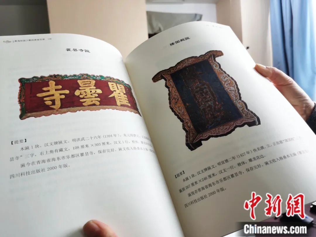 古籍保護(hù)人員展示介紹明代朱元璋撰寫的青海瞿曇寺匾(左)的出版書籍。張?zhí)砀?攝