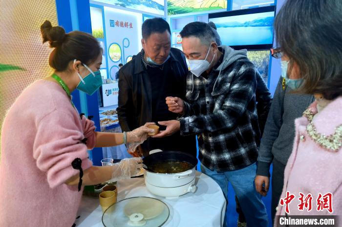 圖為杭州市民品嘗茶卡羊肉?！±铍h 攝
