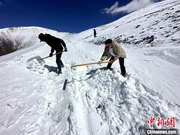 圖為生態(tài)管護人員在巡護道路上清雪。　丁巴達杰 攝