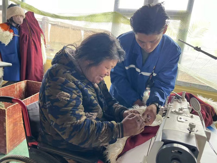 扎西奪爾登幫助殘疾員工裁剪。阿壩州文明辦供圖