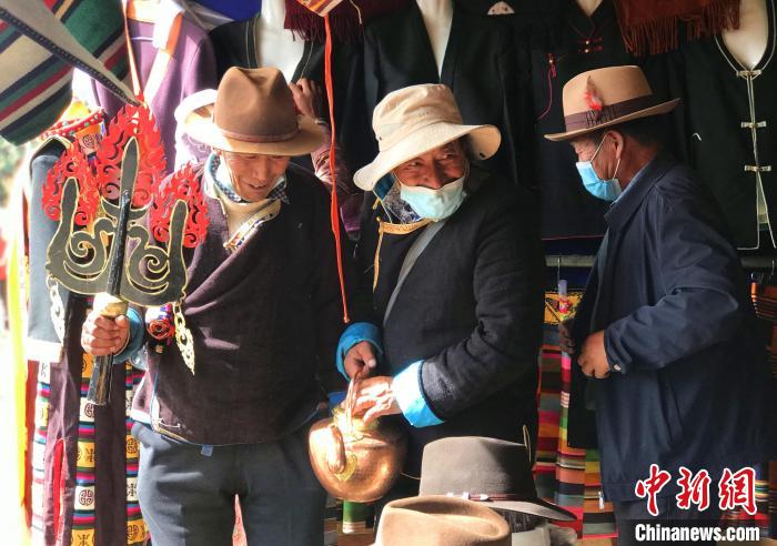 圖為三位藏族老人在集市上聊天交談?！∪轿木?攝