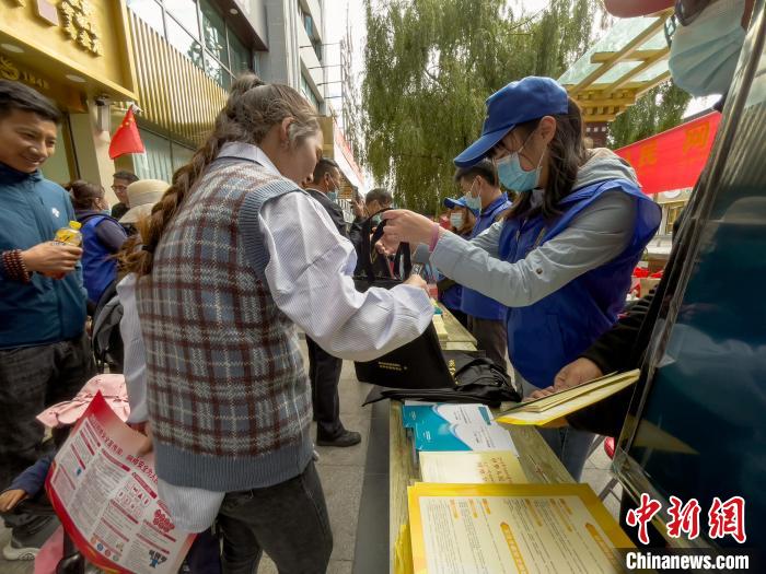 圖為志愿者為市民發(fā)放網(wǎng)絡(luò)安全宣傳手冊(cè)?！≈x牧 攝