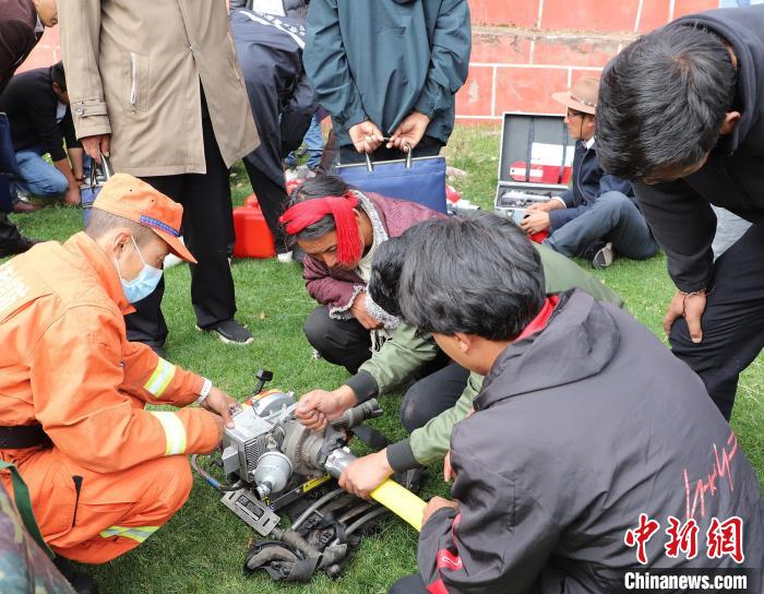 圖為森林消防員為護林員講解滅火裝備的使用方法。　昌都市森林消防支隊 供圖