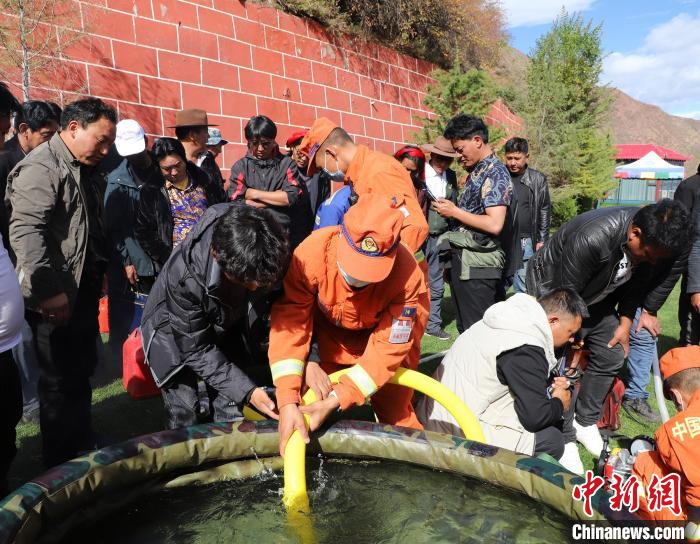 圖為森林消防員為護林員講解滅火裝備的使用方法。　昌都市森林消防支隊 供圖