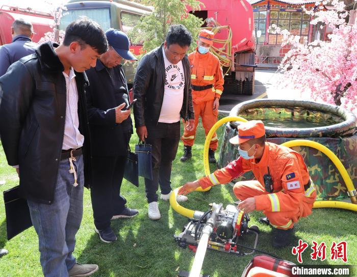 圖為森林消防員為護林員講解滅火裝備的使用方法?！〔际猩窒乐ш?供圖