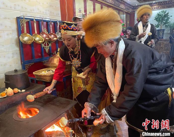 圖為人們?cè)诨鹕峡竟?jié)日美食“結(jié)達(dá)”?！∪轿木?攝