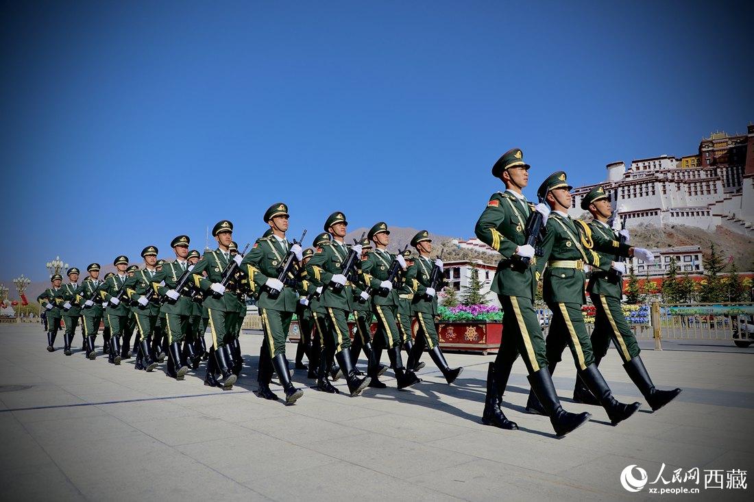 國旗護衛(wèi)隊隊員緊握鋼槍，踏著威武雄壯的步伐，走向國旗臺。人民網(wǎng) 次仁羅布攝