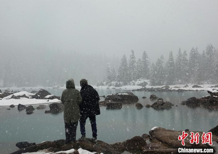 游客欣賞雪中然烏湖。　冉文娟 攝