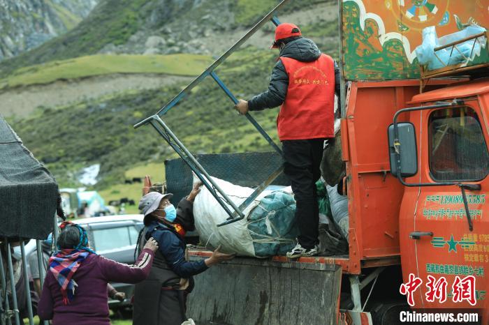 圖為工作人員幫助牧民們卸家具?！÷蹇?攝