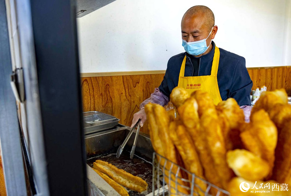 早餐店老板正在炸油條。人民網(wǎng) 次仁羅布攝