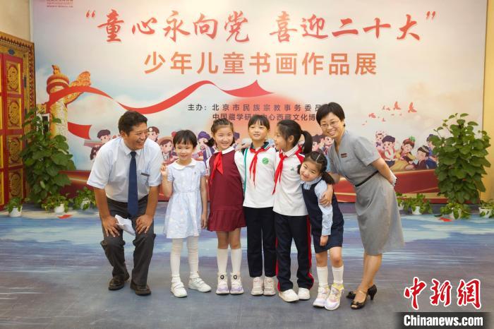 圖為與會嘉賓與入選畫作的“小作者”們在展覽上合影?！≈袊貙W(xué)研究中心供圖