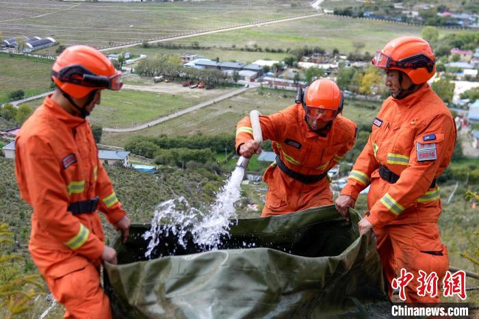 技能大練兵過(guò)程中，消防員在陡坡上向蓄水池注水?！±顕?guó)燾 攝