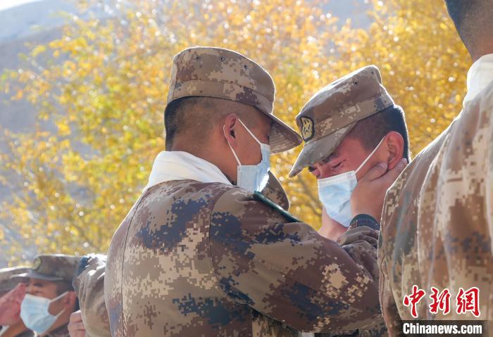 圖為什布奇邊防連退伍老兵與戰(zhàn)友相擁而泣，依依惜別?！⌒觳?攝