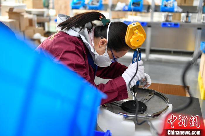 圖為工人正在組裝炊具?！∝暩聛硭?攝