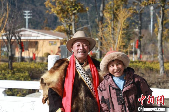 圖為林芝市巴宜區(qū)布久鄉(xiāng)仲果村村民桑杰與孫子一起參加藏歷新年活動?！埩?攝
