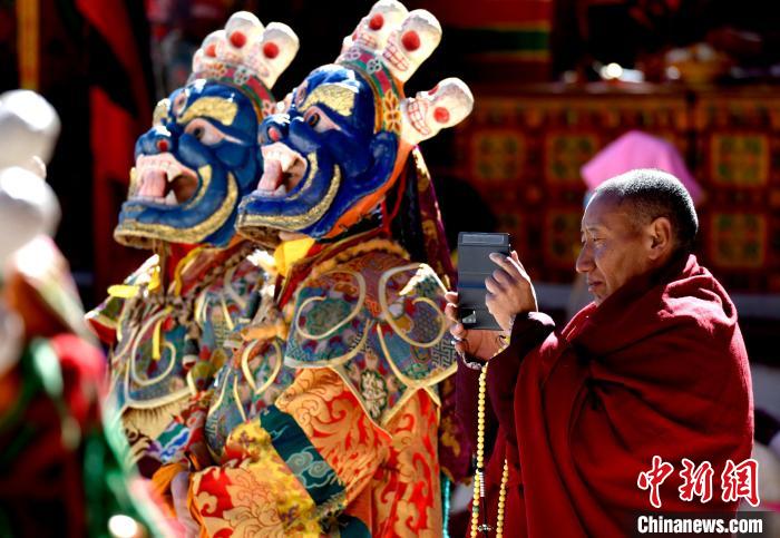 2月19日，正在拍攝跳神活動(dòng)的僧人?！±盍?攝