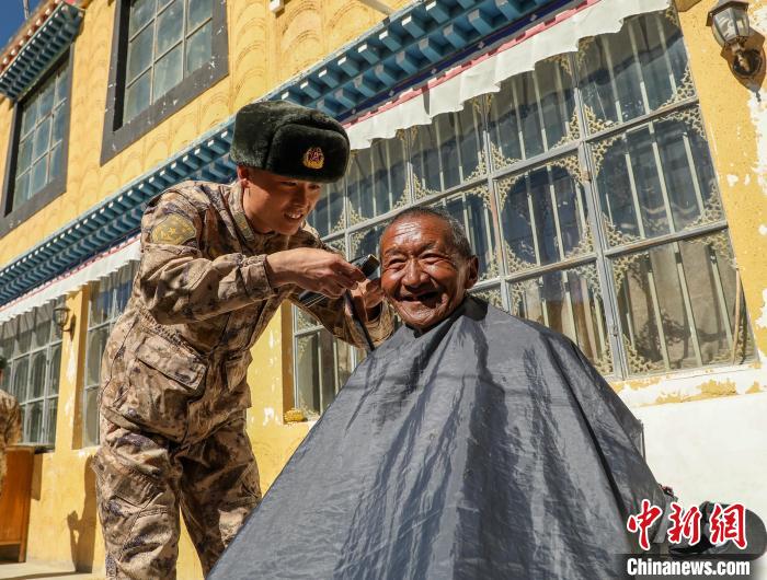 圖為阿里軍分區(qū)某邊防團官兵為駐地群眾理發(fā)迎藏歷新年?！〉┰鰝愔?攝