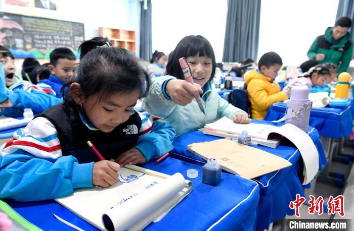 3月14日，西藏拉薩市第一小學(xué)一年級六班學(xué)生白瑪朗珍(圖左)在藏語文課上書寫藏文?！±盍?攝