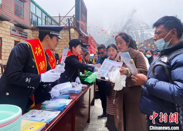圖為山南玉麥邊境派出所民警為轄區(qū)群眾發(fā)放法律知識宣傳單?！＄婗?　攝