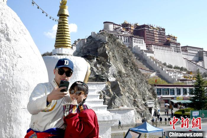 4月17日，游客身著藏式元素服裝在拉薩布達(dá)拉宮觀景臺拍照留念?！±盍?攝