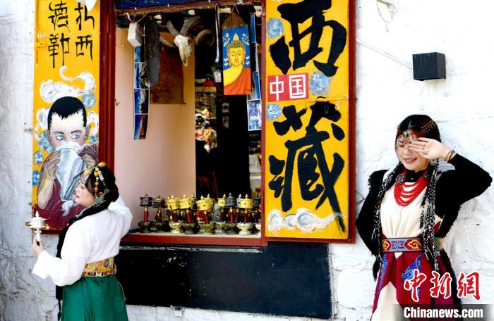 4月17日，游客身著藏式元素服裝在拉薩八廓街拍照留念。　李林 攝