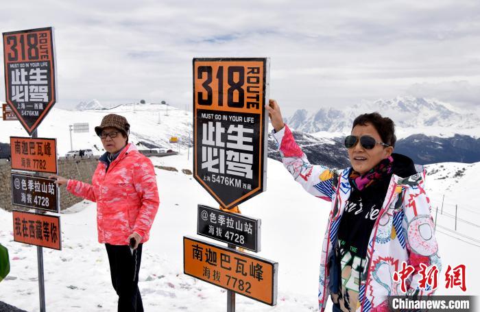 圖為5月14日，西藏林芝色季拉山觀景臺，游客與南迦巴瓦峰合影?！±盍?攝
