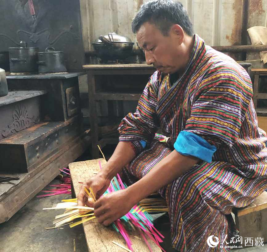 門巴族漢子愛明正在編織藤竹品。